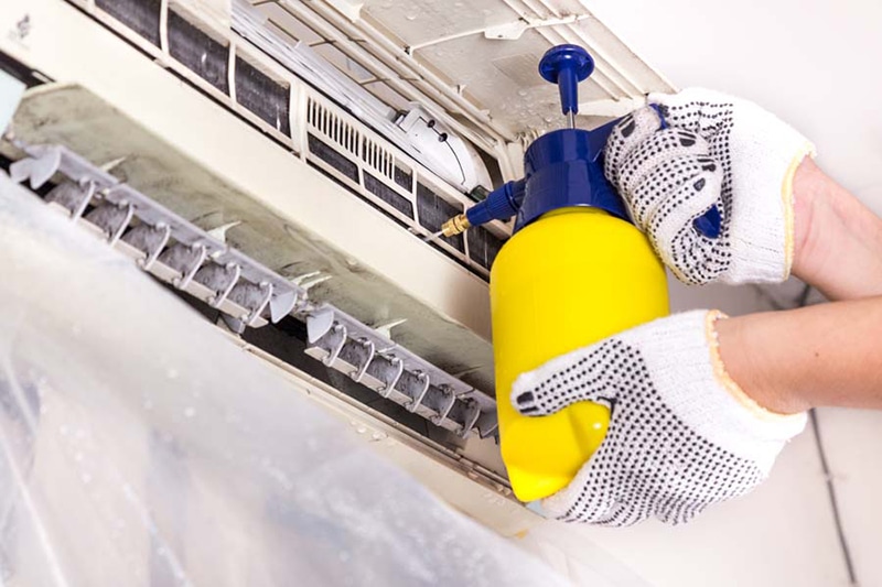 Technician performing maintenance on ac unit