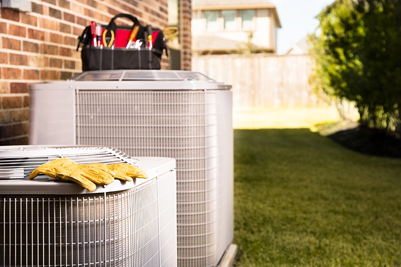 Service Industry: Work tools on air conditioners. Outside residential home.