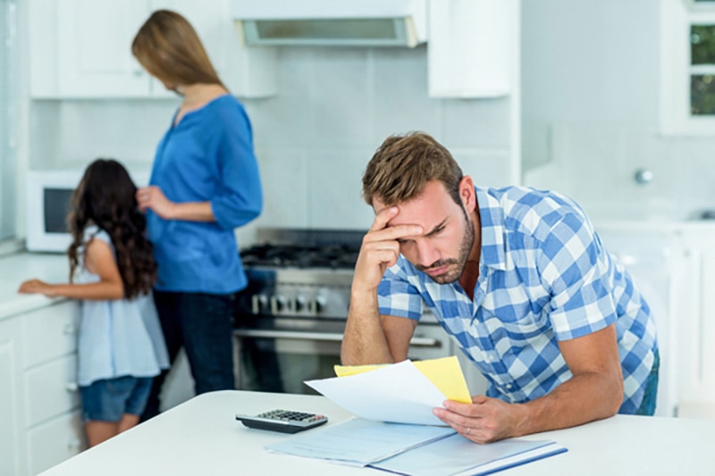 man in a kitchen stressing over a bill