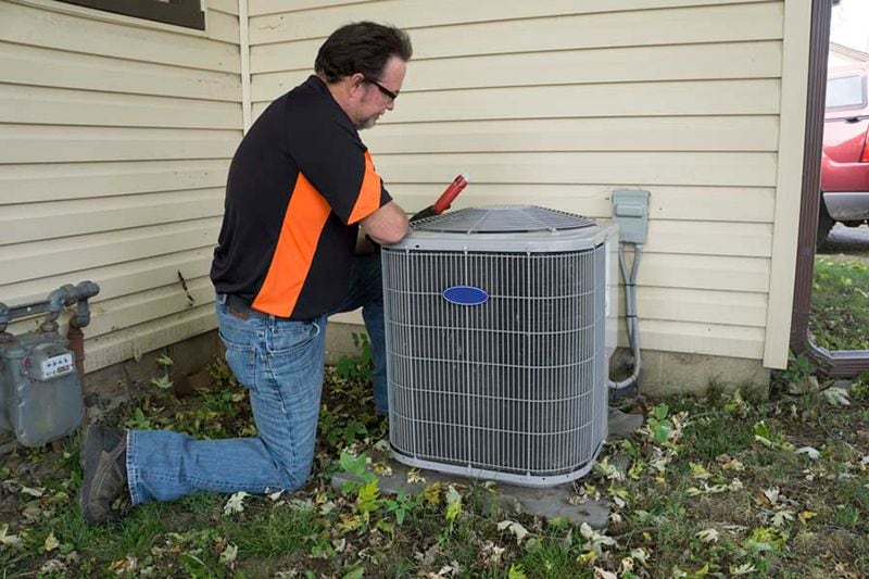 Image of a technician working on an AC unit. Do I Really Need an AC Tune-Up?
